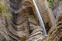 France, Alpes-de-Haute-Provence, Low angle view of waterfall on eroded rock — Stock Photo