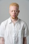 Студийный портрет альбиноса в белой рубашке с закрытыми глазами — стоковое фото