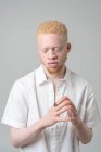 Студийный портрет альбиноса в белой рубашке с закрытыми глазами — стоковое фото