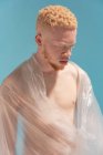 Studioporträt eines hemdlosen Albino-Mannes in Plastikfolie gewickelt — Stockfoto