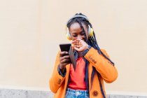 Італія, Мілан, Жінка з навушниками і смарт-телефоном на вулиці — стокове фото