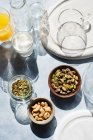 Overhead view of bowls with nuts and glasses on table — Stock Photo