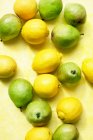 Вид сверху на лимоны и груши на желтой скатерти — стоковое фото