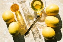 Vue aérienne des citrons et des boissons sur la surface du marbre — Photo de stock