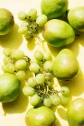 Вид сверху на груши и виноград на желтой скатерти — стоковое фото