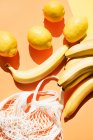 Blick über den Kopf auf Bananen, Zitronen und Netzbeutel — Stockfoto