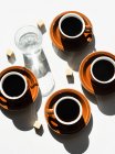 Vista aérea de xícaras de café expresso e vidro de água — Fotografia de Stock