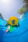 España, Mallorca, Mujer sonriente nadando en piscina con anillo inflable - foto de stock