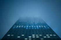Reino Unido, Londres, HSBC Tower en la niebla al atardecer visto desde abajo - foto de stock