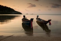 Таиланд, остров Самуи, традиционные лодки пришвартованы на пляже на закате — стоковое фото