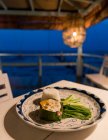 Камбодия, кеп, фиш-бек на тарелке в клубе Sailing Club в сумерках — стоковое фото
