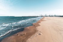Испания, Валенсия, Вид с воздуха на пляж и море с портовыми кранами вдали — стоковое фото