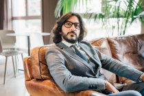 Italien, Porträt eines Geschäftsmannes, der auf einem Sofa im Kreativstudio sitzt — Stockfoto