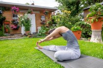 UK, London, Woman exercising on lawn in front of house — Stock Photo