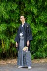 Reino Unido, Retrato de un joven con kimono sujetando abanico en el parque - foto de stock