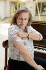 Austria, Retrato de pianista con vendaje adhesivo en el brazo - foto de stock