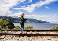 Estados Unidos, Alaska, Hombre fotografiando vías férreas en el Parque Nacional Kenai Fjords - foto de stock