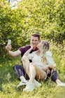 Austria, Vienna, Smiling young taking selfie in park — Stock Photo