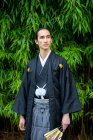 Reino Unido, Retrato de jovem vestindo quimono segurando ventilador no parque — Fotografia de Stock