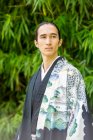 UK, Portrait of young man wearing kimono in park — Stock Photo