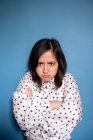 Retrato de estudio de mujer enojada sobre fondo azul - foto de stock