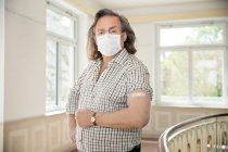 Austria, Portrait of man in face mask with adhesive bandage on arm — Stock Photo