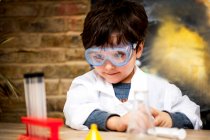 Мальчик проводит научные эксперименты дома — стоковое фото