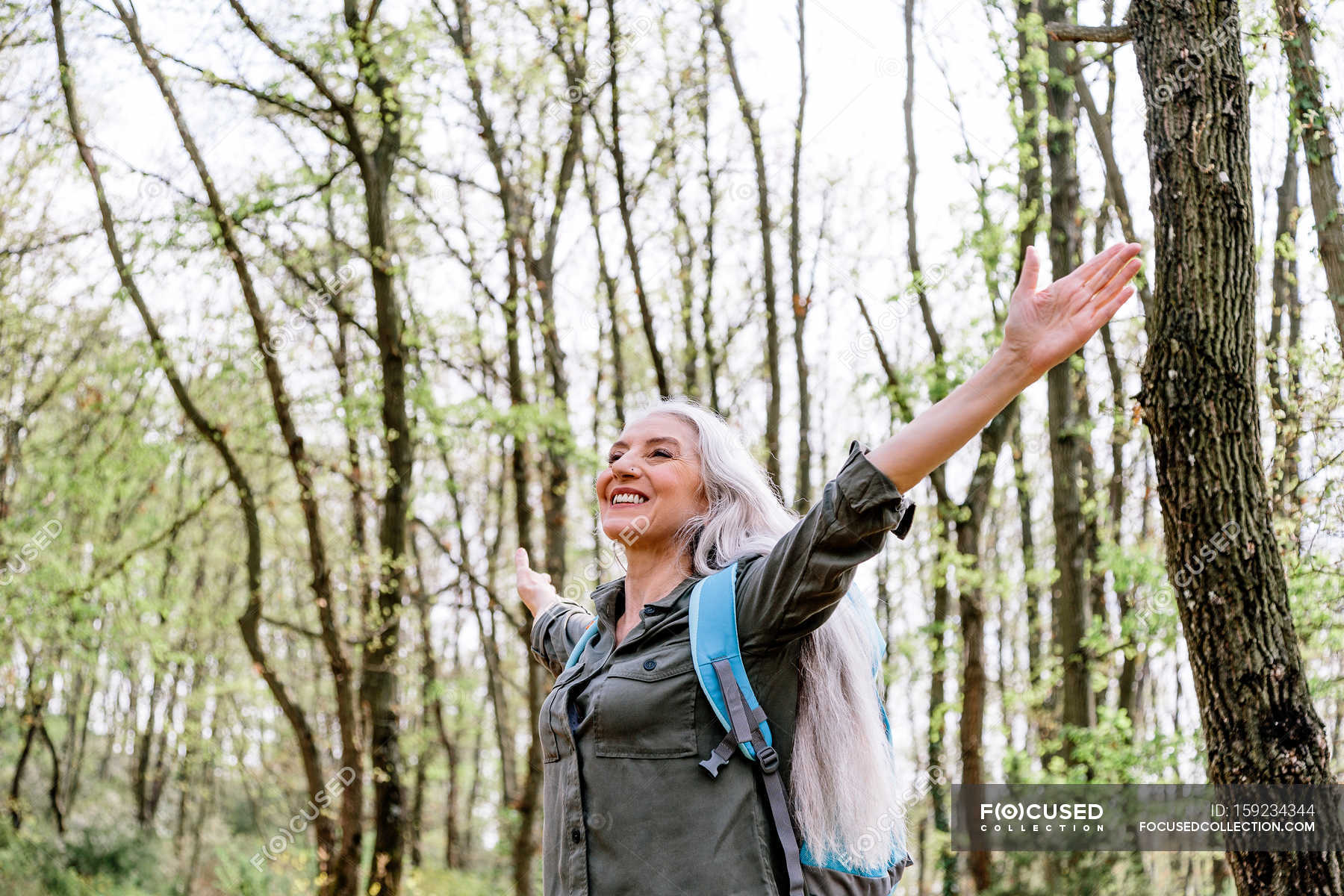 Reife Frau mit offenen Armen im Wald - Tragen, Graue Haare - Stock Photo #1...