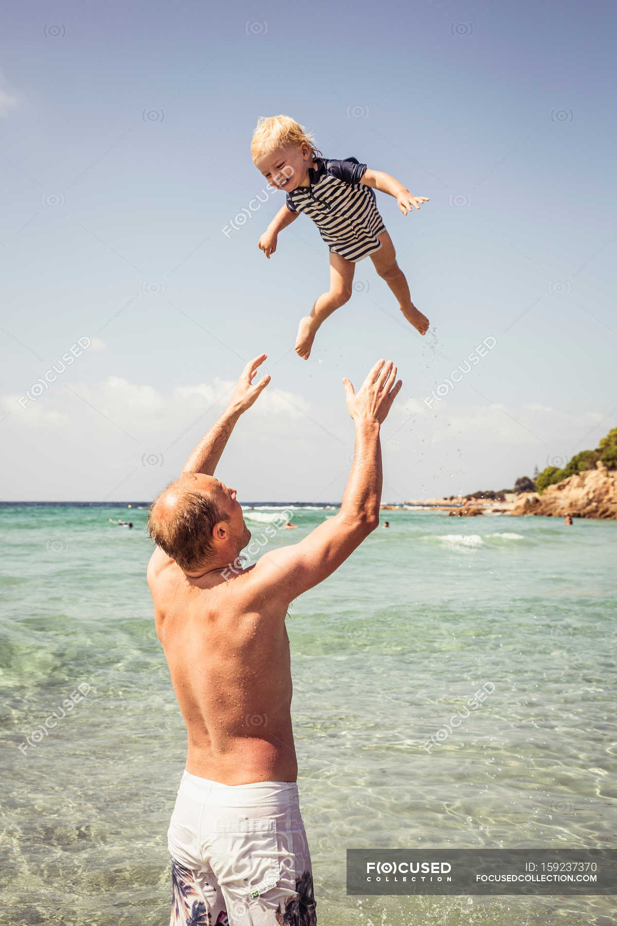 Father throwing young son in air — escape, outdoors Stock Photo 159237370