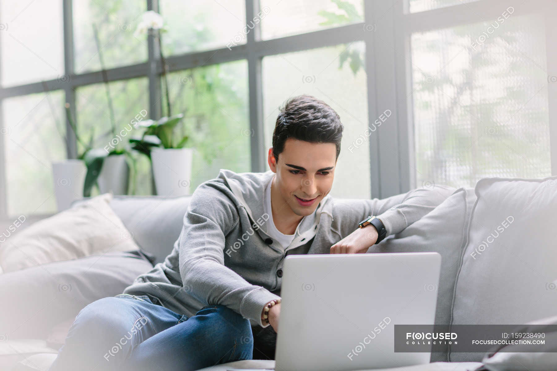 Человек сидит на диване с ноутбуком — Естественное освещение, бизнес -Stock Photo