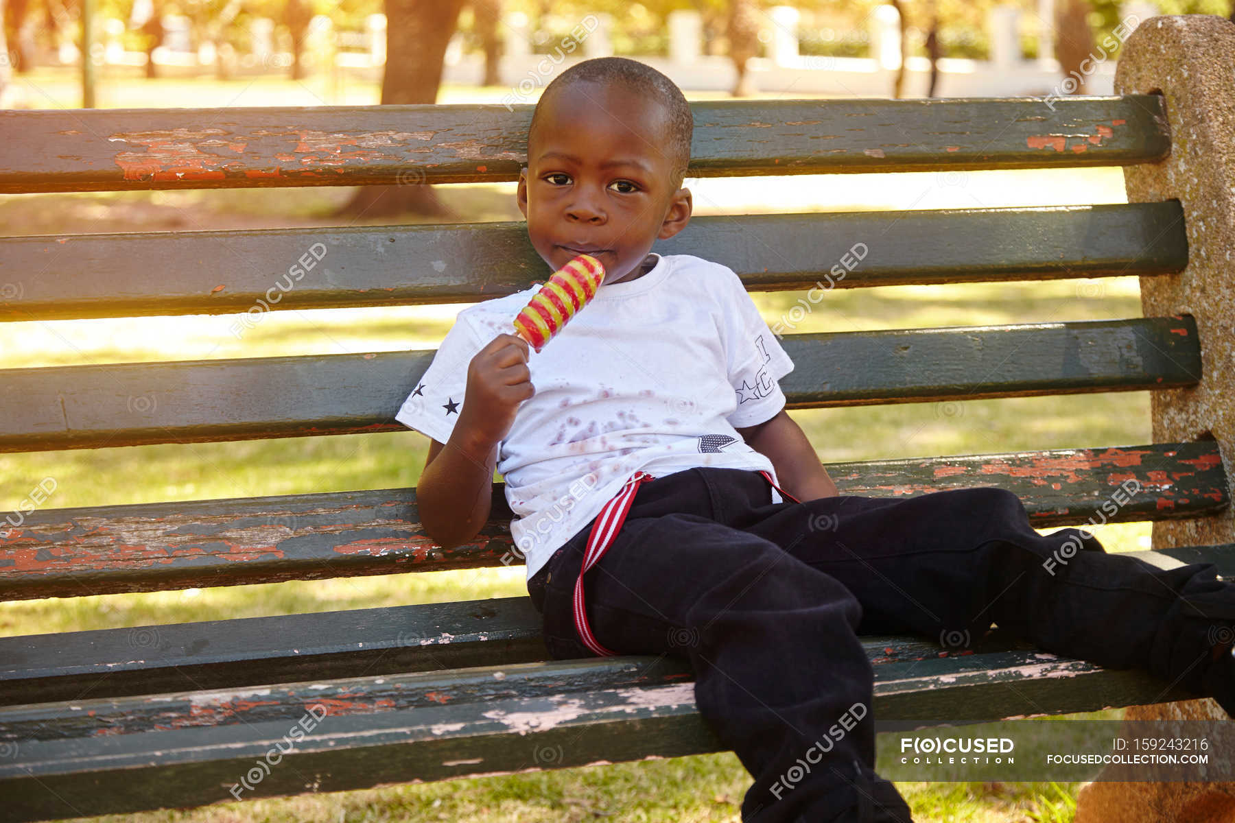 Boy eating ice lolly — people, Wearing - Stock Photo | #159243216