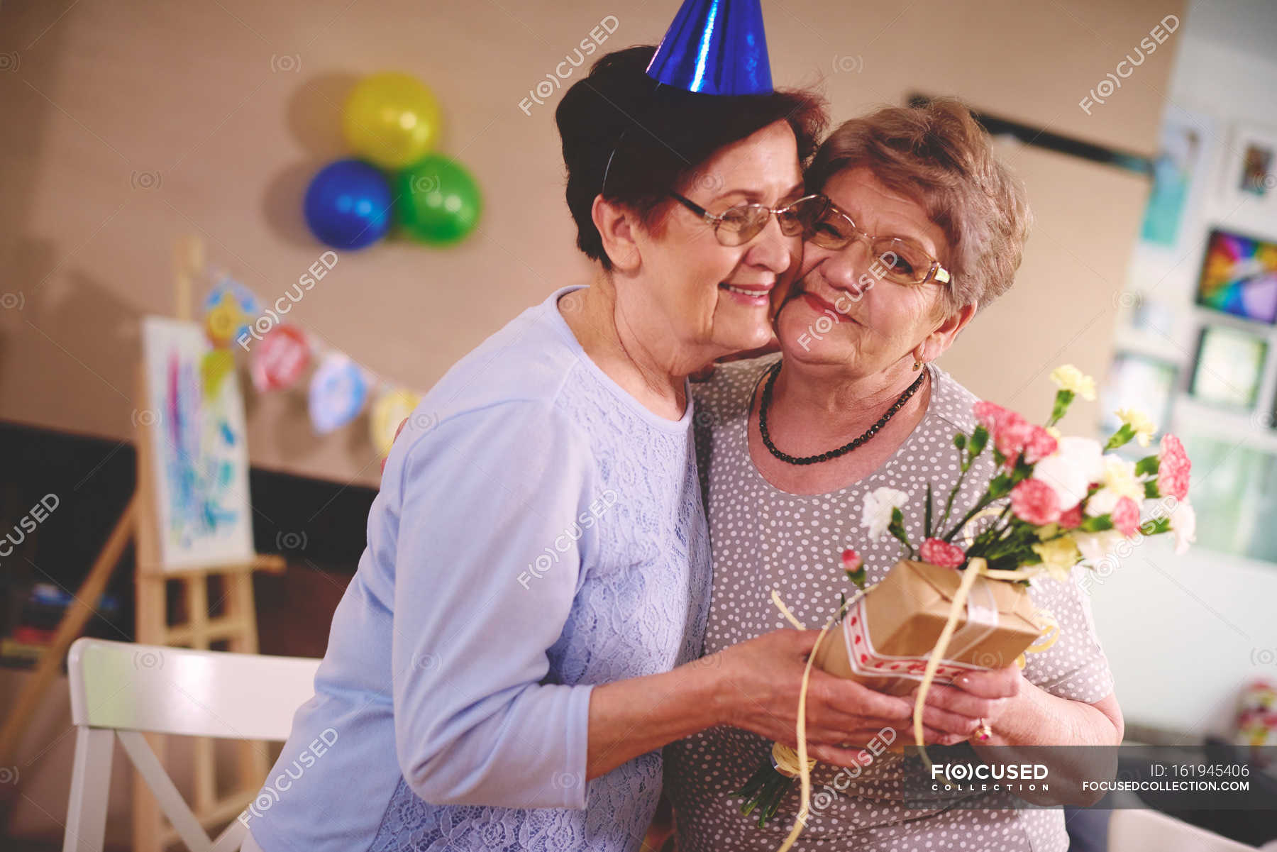 Woman giving flowers to friend — smiling, Waist Up Stock Photo 161945406