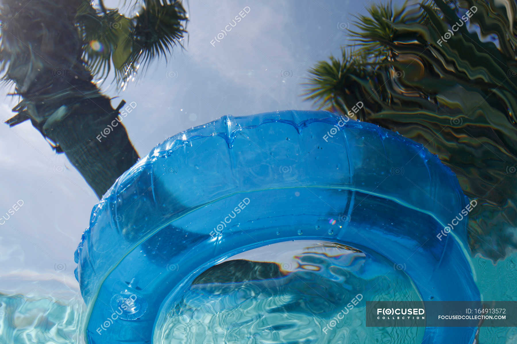 Blue Inner tube viewed from underwater — blue sky, swimming pool ...