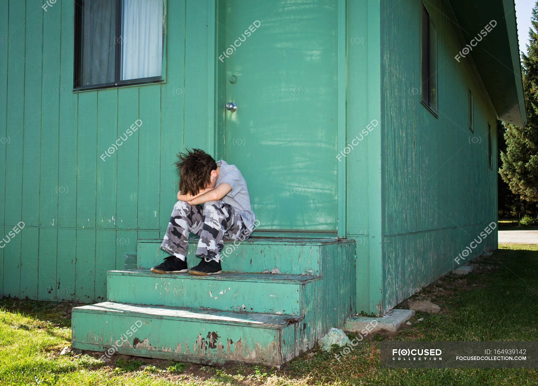 boy-sulking-on-steps-depression-frustration-stock-photo-164939142