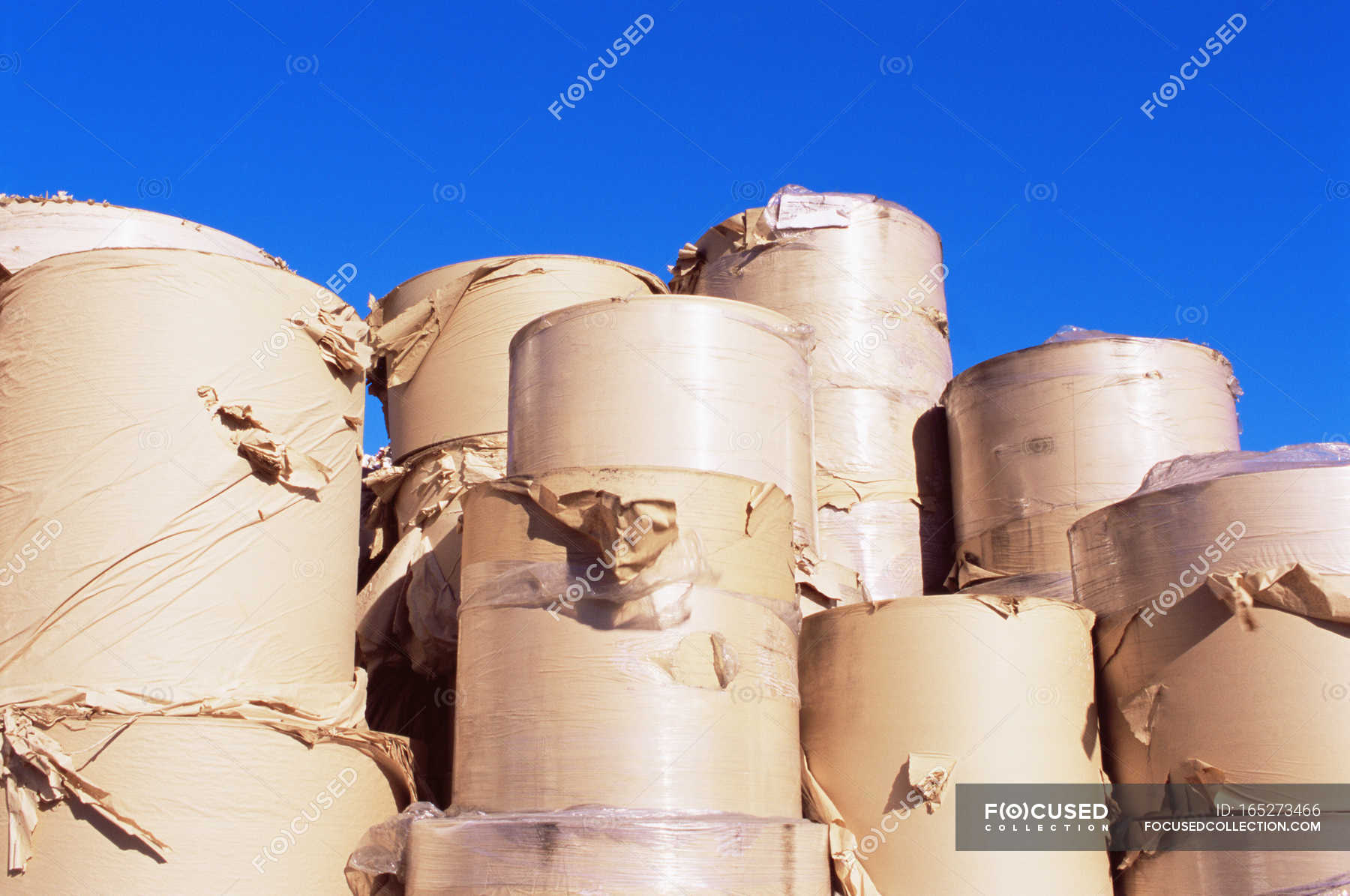 Large rolls of paper with vivid blue sky — sunlight, paper rolls