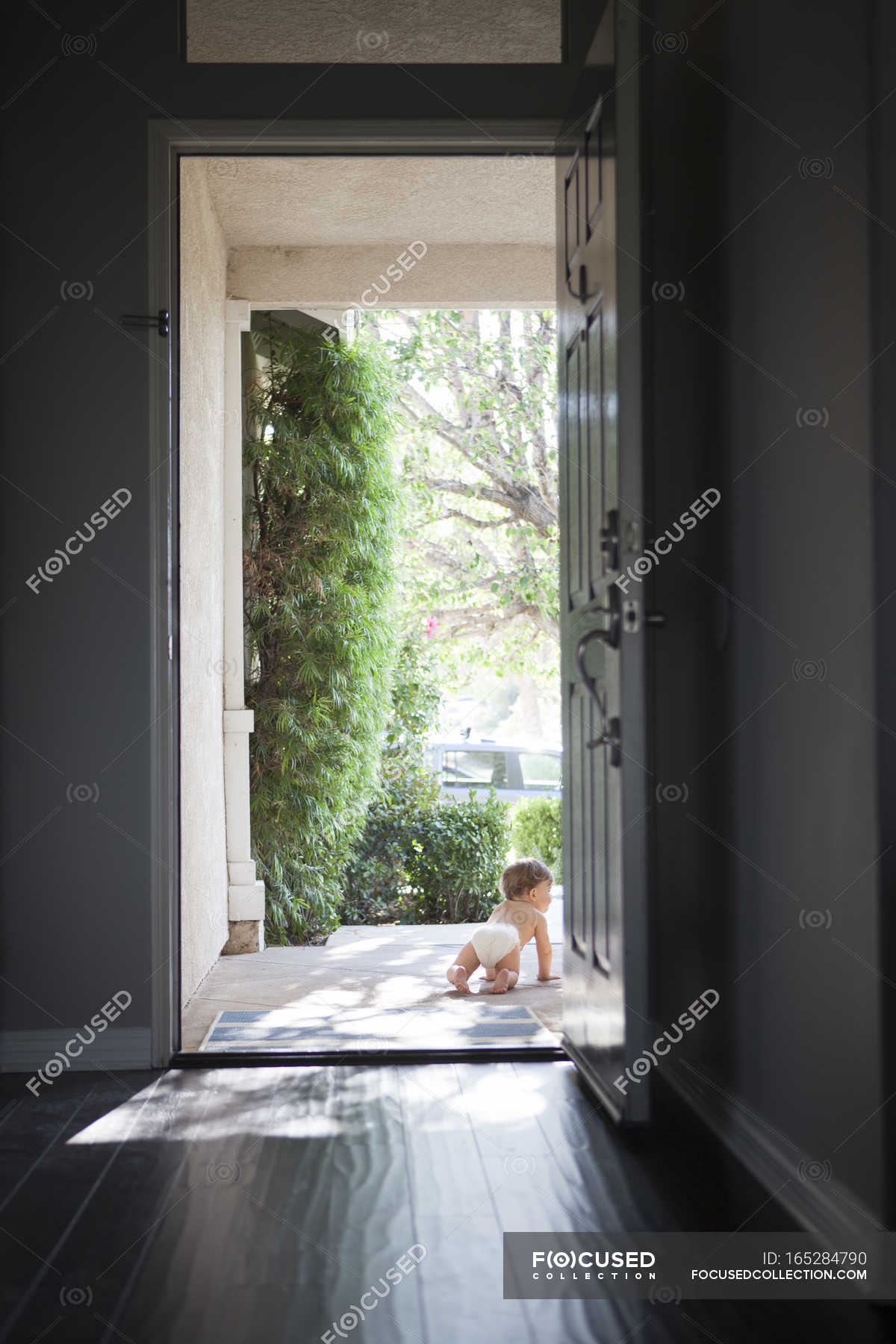 Rear View Of Baby Boy Wearing Nappy Crawling Through Open Front Door Rear View Of Baby Boy Wearing Nappy Crawling Through Open Front Door Stock Photos
