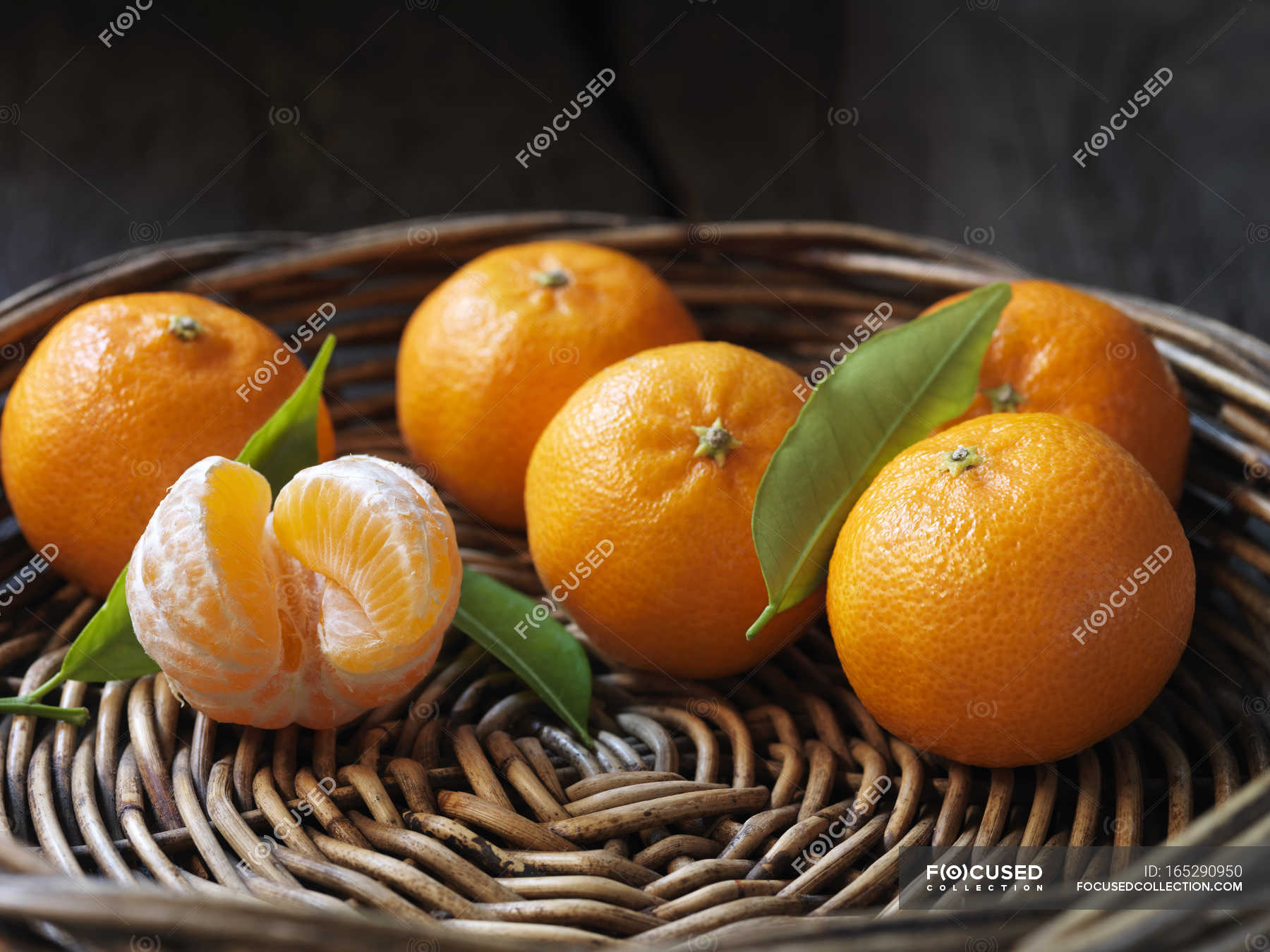 Fresh organic fruit, clementines with leaves in wicker bowl — Small