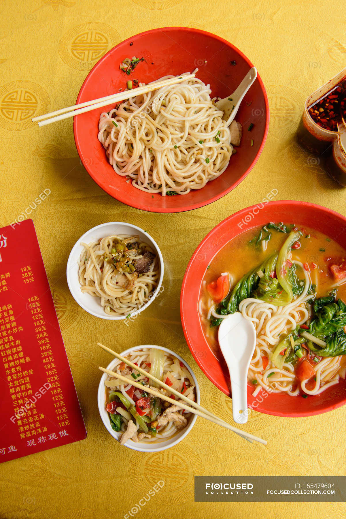 Bowls of Chinese noodle soup and menu on table — still life, national