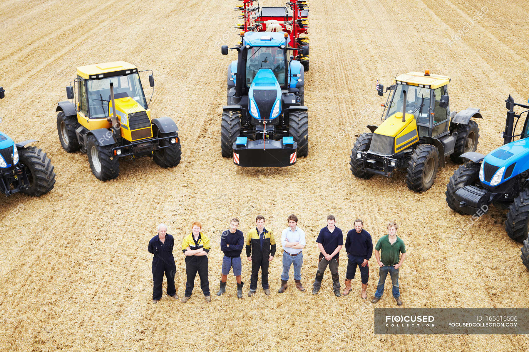 Farmers with tractors in crop field — crossed arms, In A Row Stock