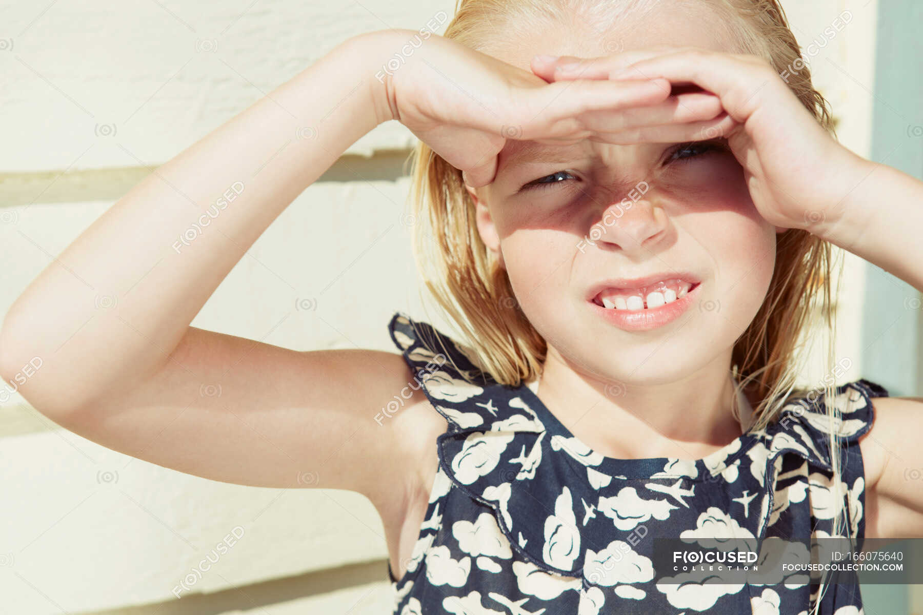 Child covering her eyes from sun glare — dress, pre adolescent girl ...