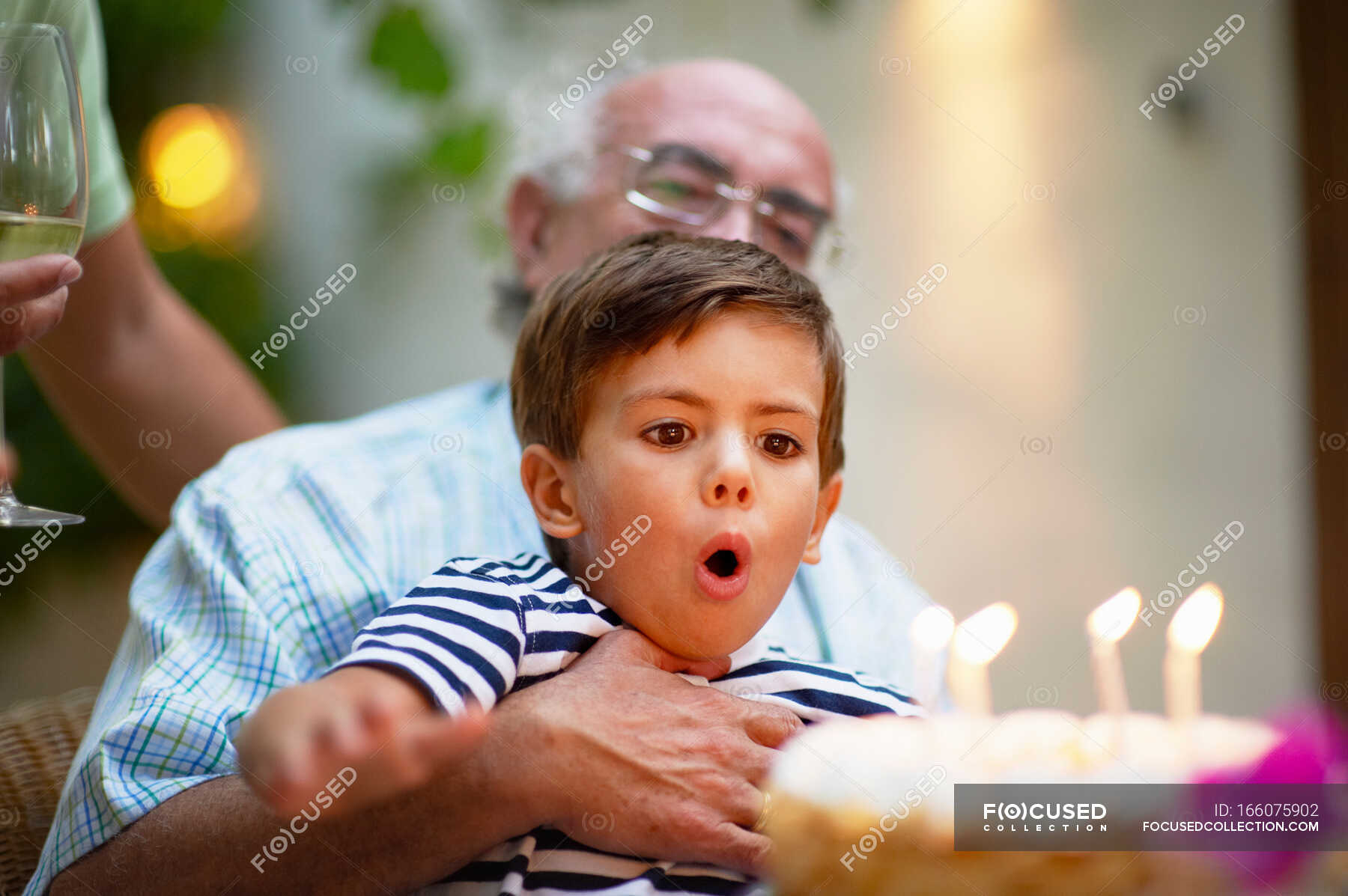 child-blowing-out-candles-on-a-cake-mid-adult-celebrations-stock