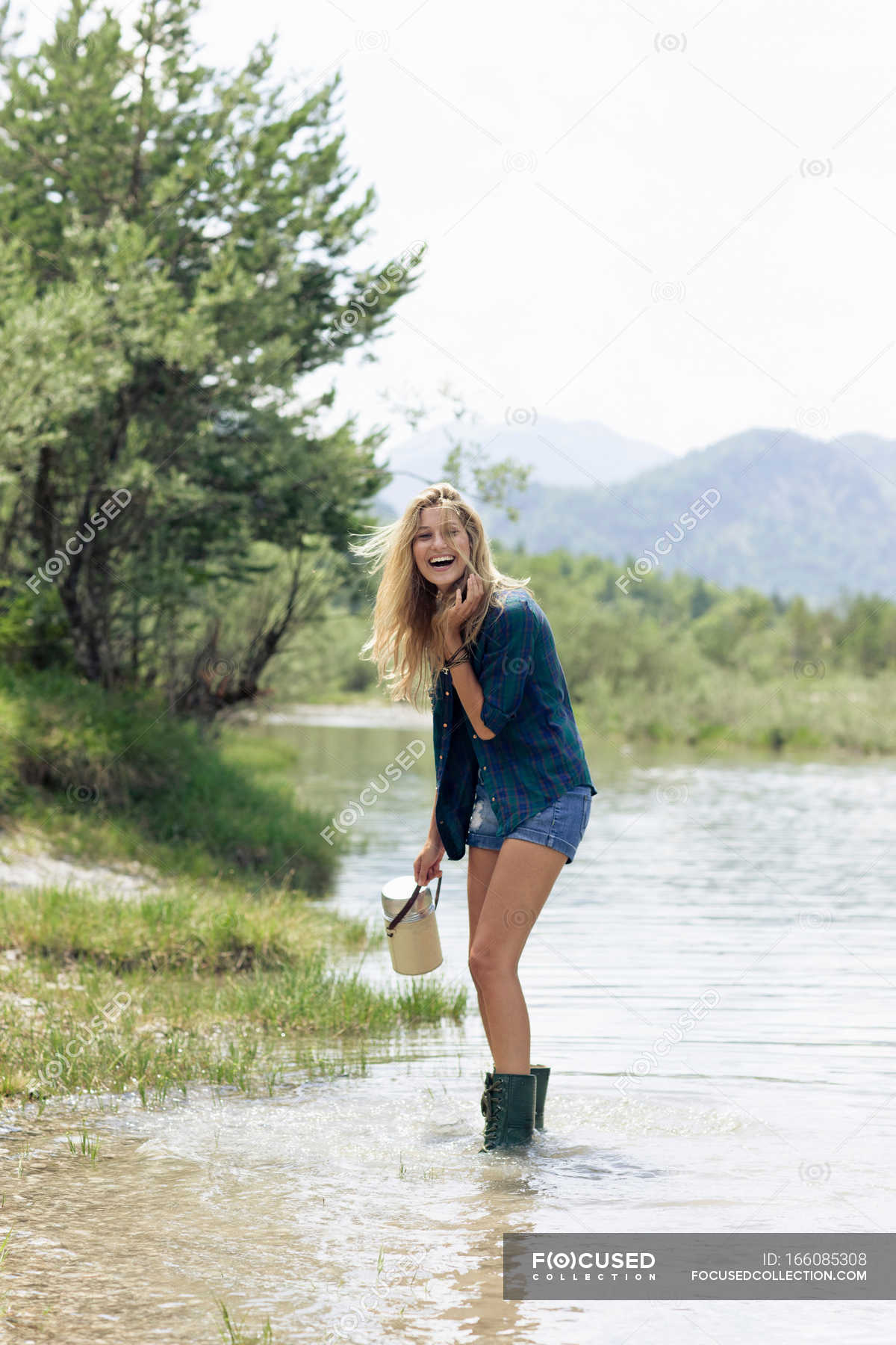 Woman in boots playing in river 