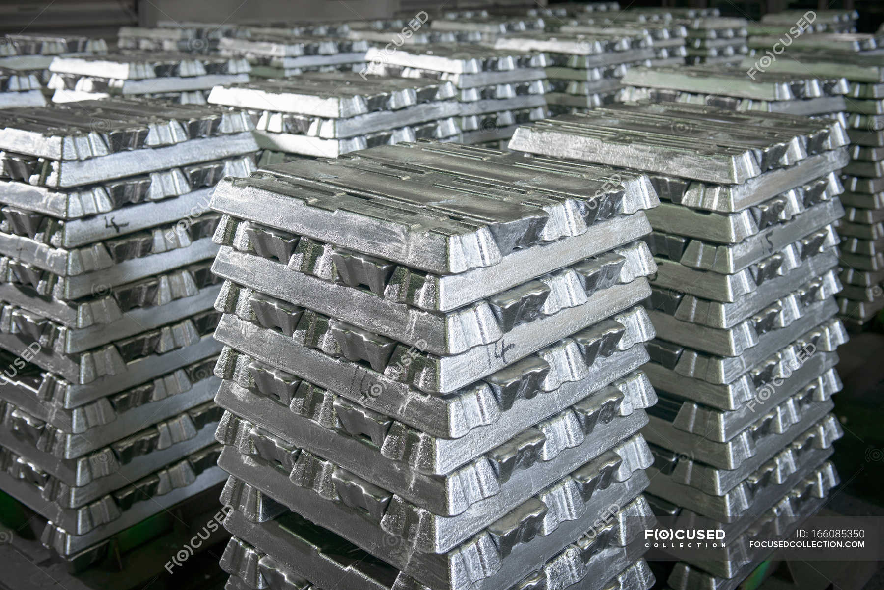 Stacked ingots in aluminium recycling plant warehouse