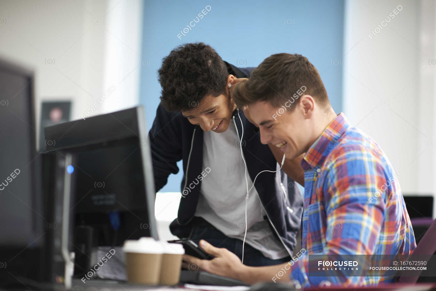 Young Male College Students At Computer Desk Laughing Whilst