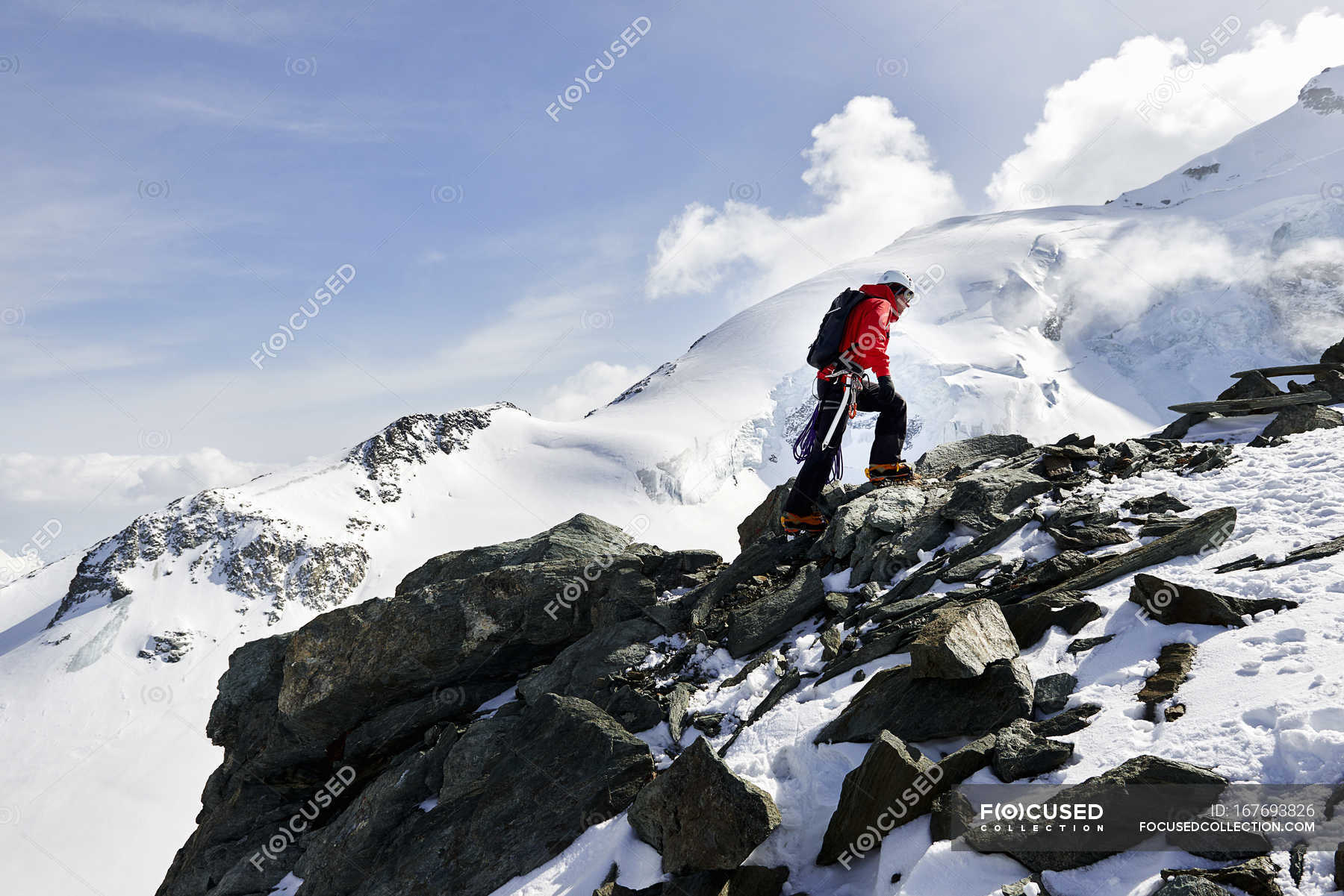 Man climbing up snow covered mountain, Saas Fee, Switzerland — Wearing