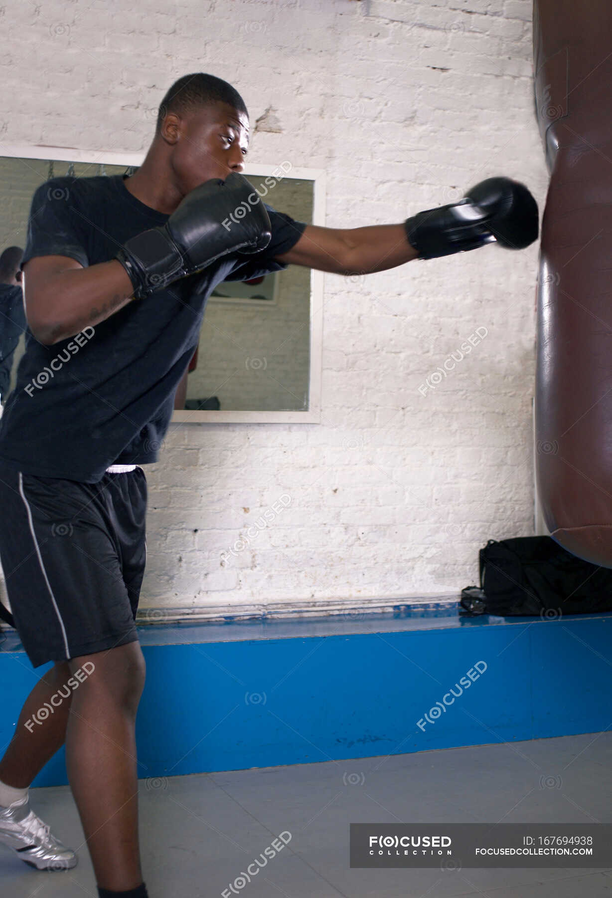 Boxer using punching bag in gym — fitness, Punch Bag Stock Photo