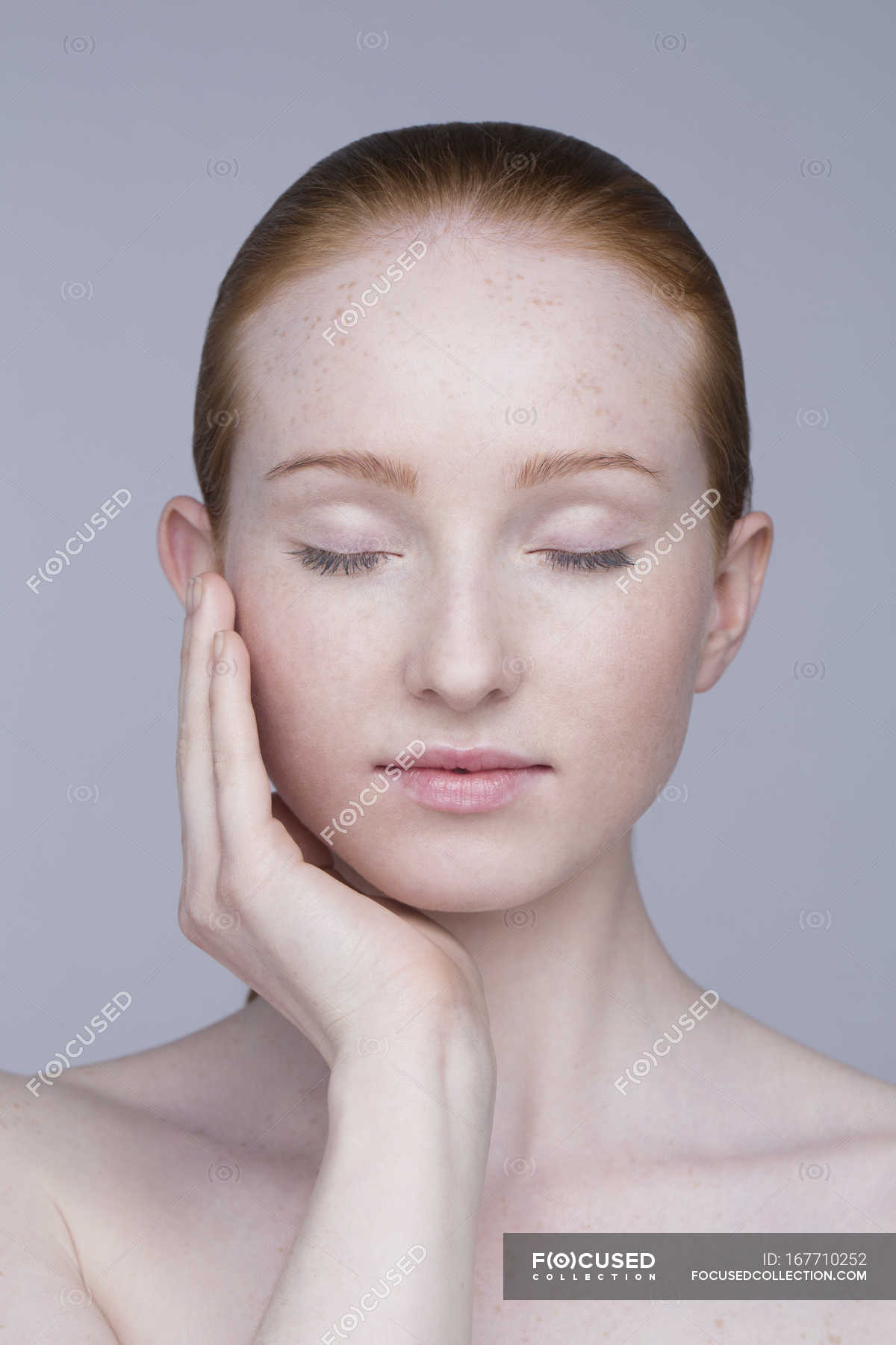 Portrait of young woman, eyes closed — head and shoulders, caucasian