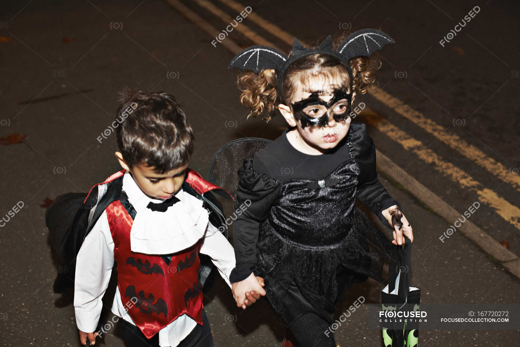 Little girl and toddler boy trick or treating at night — wings ...
