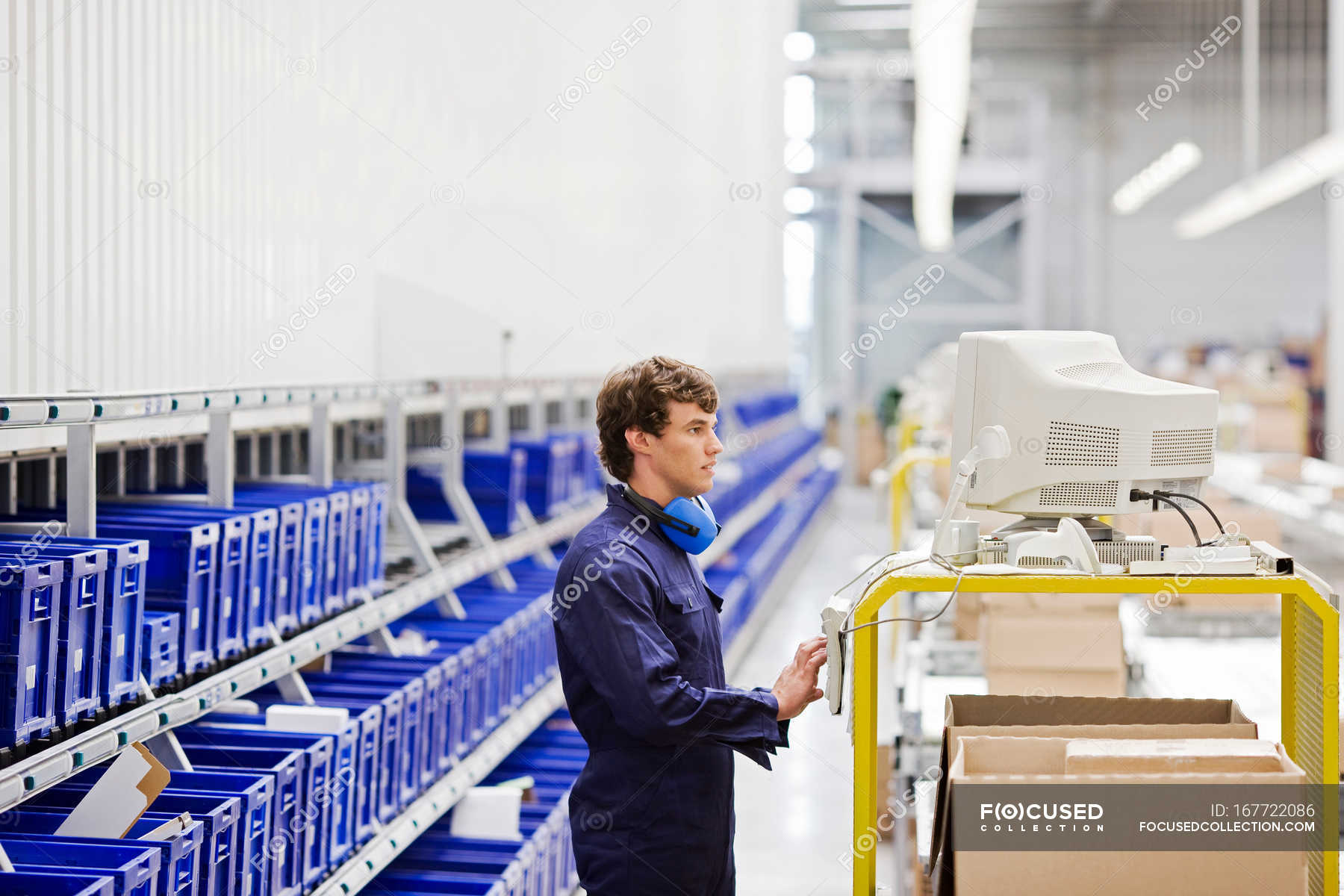 Handsome worker in uniform at workplace — factory, ear defenders