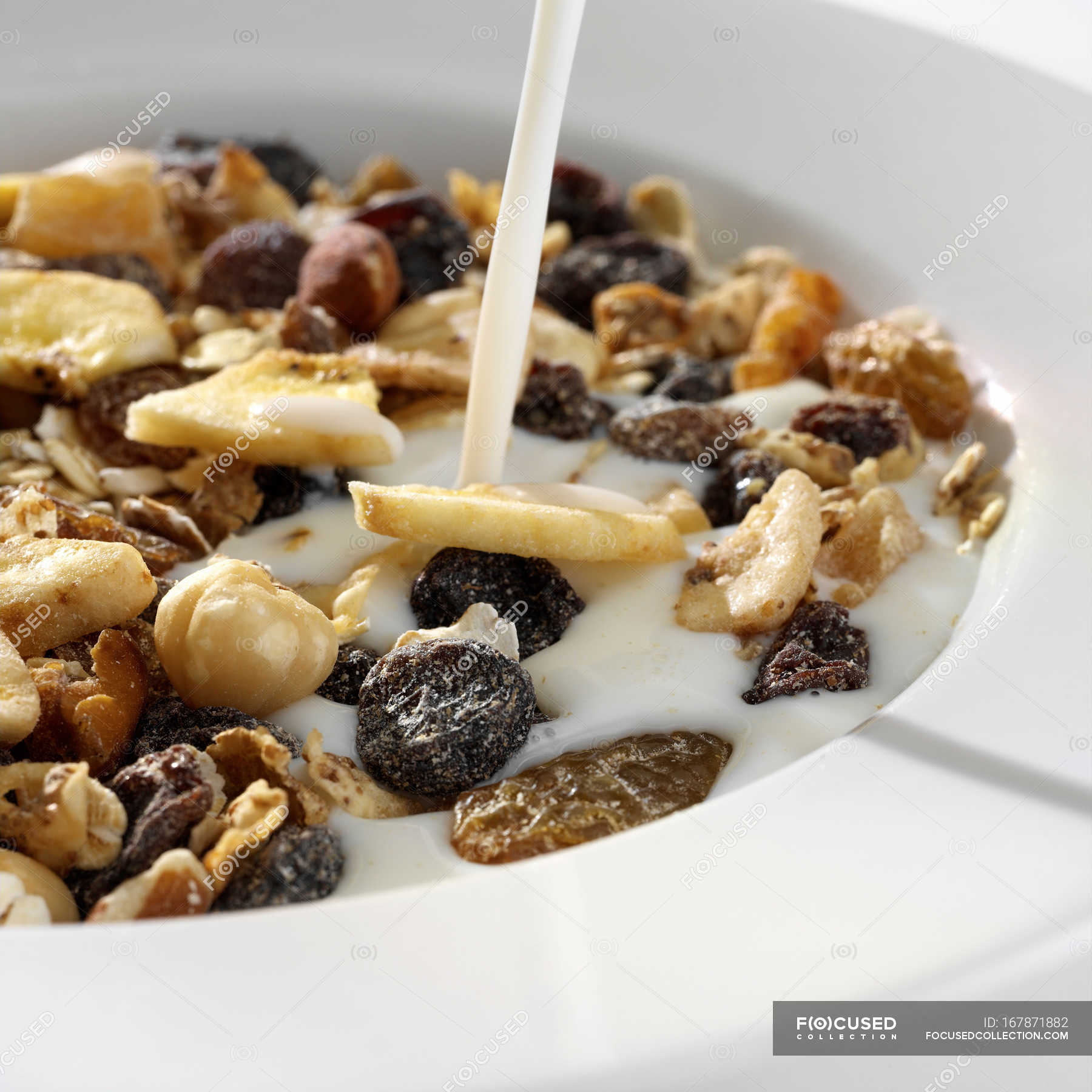 Milk pouring in bowl of muesli, close up shot — nutritive, breakfast